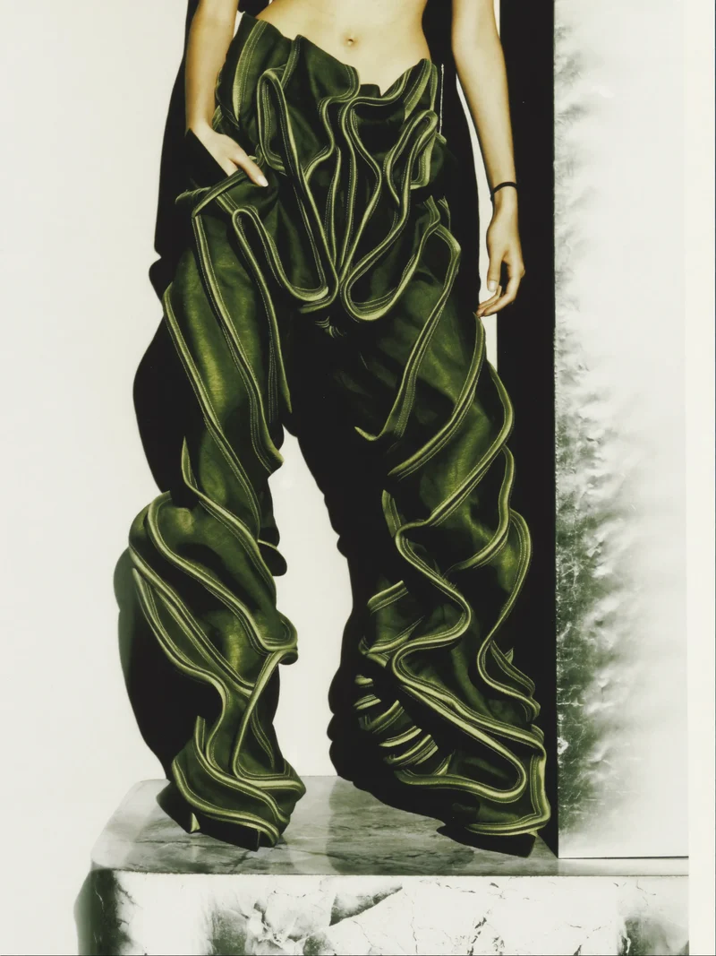 Illustration: weite Bundfaltenhose mit geschwungener Bogennaht